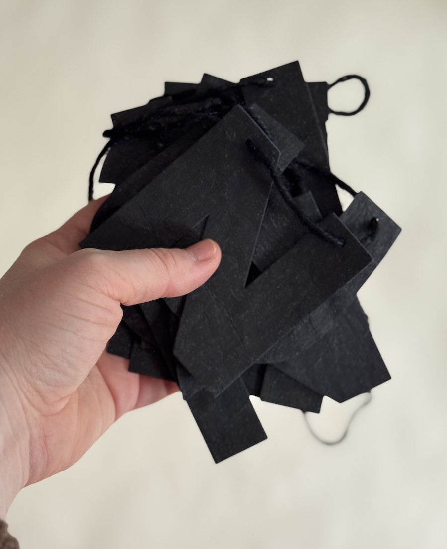 Minimalistische schwarze Lederpapier-Girlande „Nur noch eine Reihe“, ca. 110-120 cm lang, anpassbar durch Ziehen der Buchstaben, ideal für Wohnzimmer und Events