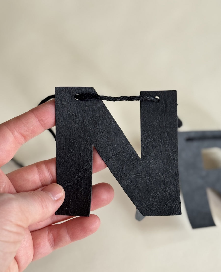 Minimalistische schwarze Lederpapier-Girlande „Nur noch eine Reihe“, ca. 110-120 cm lang, anpassbar durch Ziehen der Buchstaben, ideal für Wohnzimmer und Events