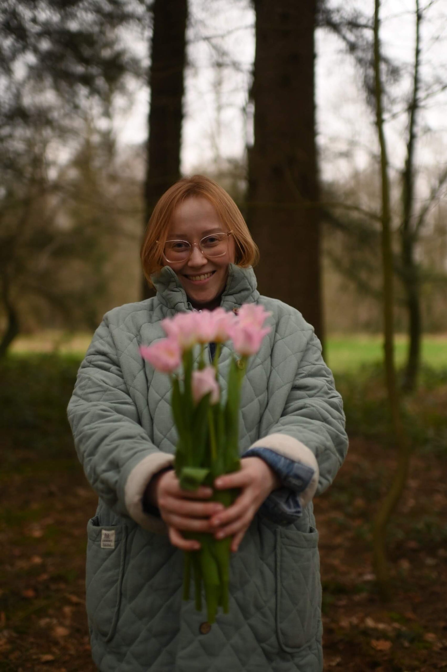 Eine Frau schenkt Blumen und lächelt freundlich
